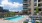 a pool and chairs outside of a building